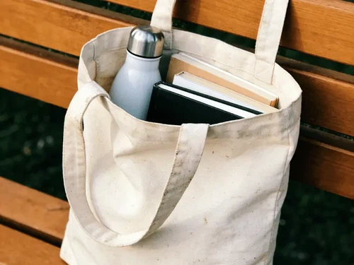 A well-worn reusable canvas tote bag still in use after years, illustrating the importance of long-term reuse for environmental sustainability A well-worn reusable canvas tote bag still in use after years, illustrating the importance of long-term reuse for environmental sustainability